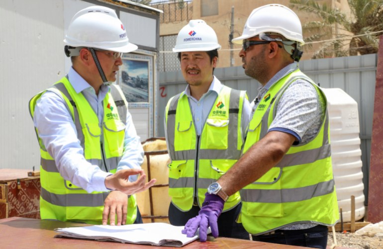 Supervisors talk at the construction site for a school, part of the Iraq-China "oil for construction" deal, in the Sumer neighbourhood of Nasiriyah city, in Iraq's southern Dhi Qar province, on July 20, 2022. China has gained a major foothold in oil-rich Iraq, shaking up Western domination in fields from energy to construction, even as some warn infrastructure projects could leave Baghdad in debt. (Photo by Asaad NIAZI / AFP)