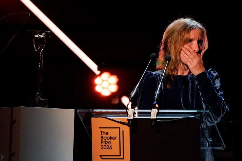 Samantha Harvey reacts while speaking on stage after winning the Booker Prize award 2024, in London, Tuesday, Nov. 12, 2024. (AP Photo/Alberto Pezzali)