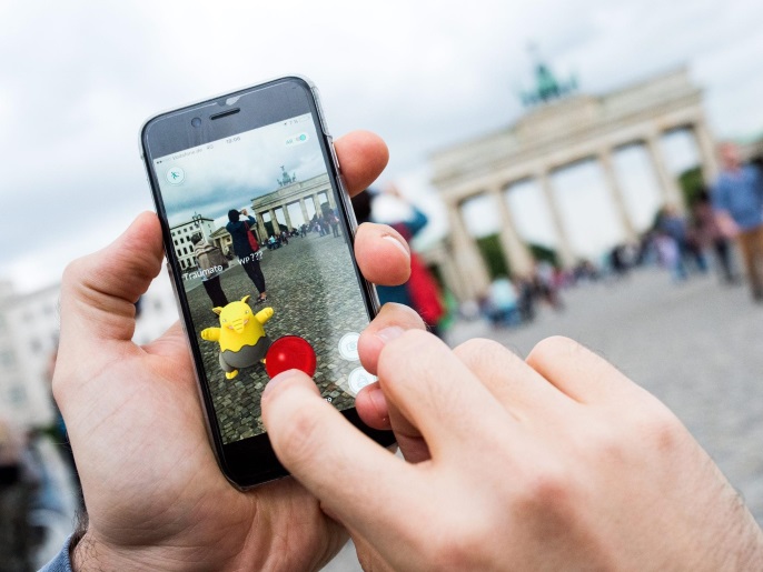 A picture made available on 14 July 2016 shows man trying to catch a pokemon called 'Drowzee' with a pokeball using the 'Pokemon Go' augmented reality mobile phone app in front of the Brandenburg Gate in Berlin, Germany, 13 July 2016. The app has been available in German app stores since 13 July. The app allows users to collect pokemon and battle against each other.