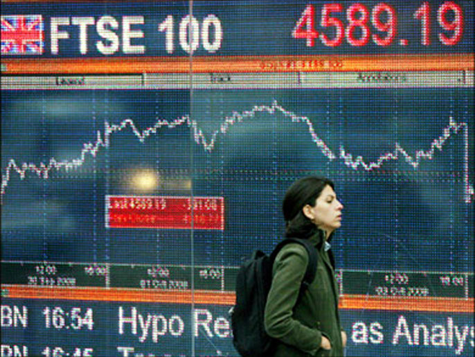 afp : A woman walks past an electronic sign showing the progress of the FTSE 100 share index in London, on October 6, 2008. The London stock market nosedived 8.65 percent