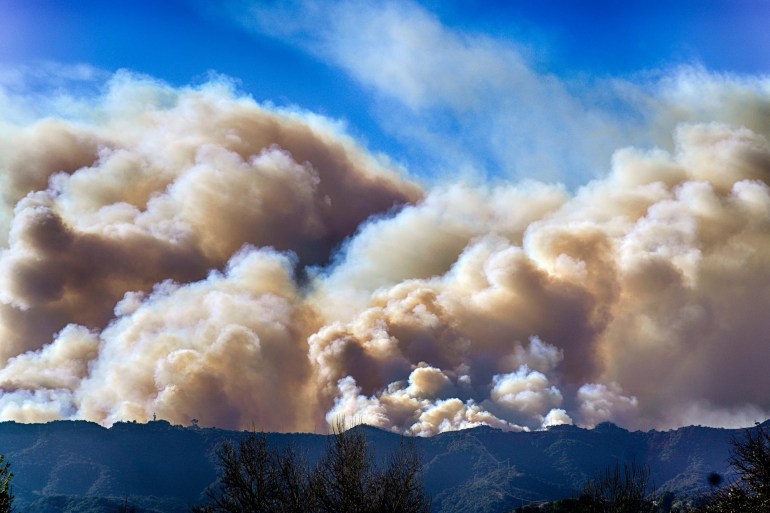 Smoke from the Palisades Fire rises over a ridge, as seen from the Encino section of Los Angeles. [Richard Vogel/AP Photo]